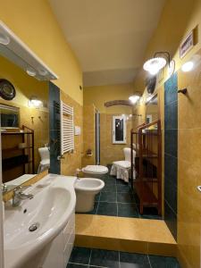 een badkamer met 2 wastafels, een toilet en een douche bij Appartamento Ristoro67 in Arezzo