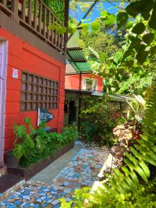 a house with a walkway in front of a building at Pura Vida Hostel in Montezuma