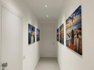 un corridoio con dipinti alle pareti di una camera di Via Zug a Castiglioncello