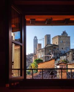 a view of a city from a window at Le Torri San Gimignano Apartments in San Gimignano