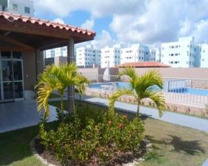 een resort met palmbomen en een zwembad bij Apartamento aconchegante próximo à UFS in São Cristóvão