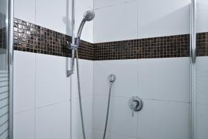 een douche in een badkamer met zwarte en witte tegels bij Winds of Change by HolyGuest in Tel Aviv