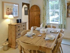 a dining room table with chairs and a wooden tableablish at Hay Cottage in Saint Stephen
