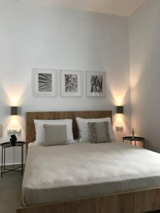 a white bedroom with a large bed with two lamps at Maria's Apartment in Knossós