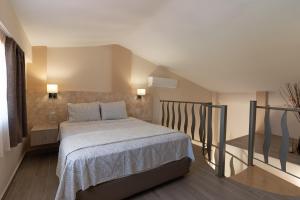 ein Schlafzimmer mit einem Bett und einer Treppe in der Unterkunft Elia Luxury Apartments in Stavros