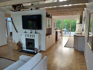 a living room with a fireplace and a tv at Holiday Home BÅSTAD Sunday to Sunday 1 in Båstad