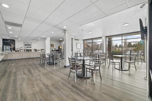 a dining room with tables and chairs and windows at Red Lion Inn & Suites Deschutes River - Bend in Bend