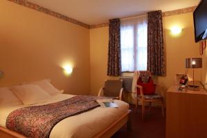 a hotel room with a bed and a window at Logis Le Luth in Mirecourt