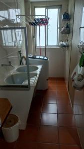 baño con bañera, lavabo y ventana en Apartamento Di Cavalcanti, en Guarapari