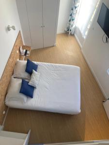 Sofá blanco con almohadas azules en una habitación en Résidence Thibaud, en Toulouse