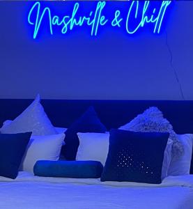 a neon sign that reads maximize and chill above a bed at Classy, Cozy, Close to downtown in Nashville