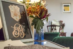 un jarrón de flores sentado sobre una mesa en Top Joe's Townhouse, en Narberth