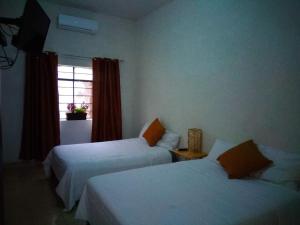 a hotel room with two beds and a window at LOS ARCOS in Agua Buena