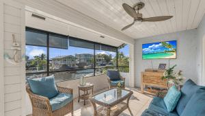 a living room with a couch and chairs and a tv at Tavernier Keys Home w/70’ Dock & 20k Boat Lift on Bayside! 3/2.5 Plus Game Room in Tavernier