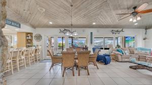 a dining room and living room with a table and chairs at Tavernier Keys Home w/70’ Dock & 20k Boat Lift on Bayside! 3/2.5 Plus Game Room in Tavernier