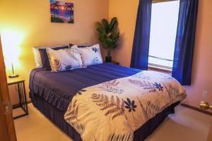 a bedroom with a bed with blue and white sheets and a window at Steve's Sweet Spot - UP Adventure Getaway in Silver City