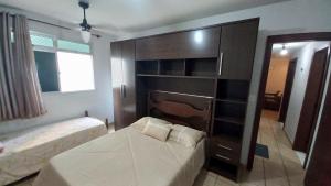 1 dormitorio con 1 cama, vestidor y 1 cama sidx sidx sidx sidx sidx sidx en Apartamento Di Cavalcanti, en Guarapari