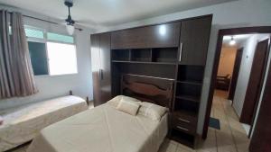 a bedroom with a bed and a dresser and a bed sidx sidx sidx sidx at Apartamento Di Cavalcanti in Guarapari