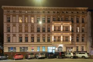 duży budynek z samochodami zaparkowanymi na parkingu w obiekcie Kamienica Centrum Apartament nr 6 w Szczecinie