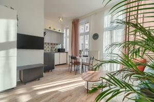 un soggiorno con cucina e tavolo di Kamienica Centrum Apartament nr 6 a Stettino