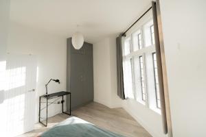 1 dormitorio con paredes blancas y ventana grande en The Apartments Kensington High Street, en Londres