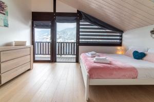 1 dormitorio con cama y ventana grande en Chalet Genepi - spectacular ski and summer home, en Saint-Gervais-les-Bains