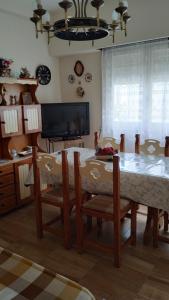 comedor con mesa, sillas y TV en La perla y el mar en Mar del Plata