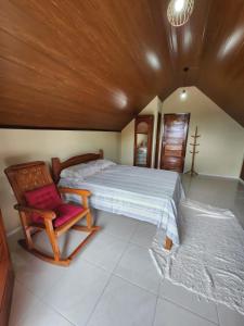 a bedroom with a bed and a wooden ceiling at Chalé Kalmaria in Guaramiranga