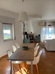 a dining table and chairs in a living room at Ericeira Ocean View Apartment in Ericeira