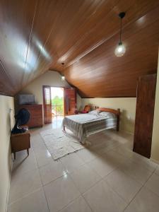 ein Schlafzimmer mit einem Bett und einer Holzdecke in der Unterkunft Chalé Kalmaria in Guaramiranga