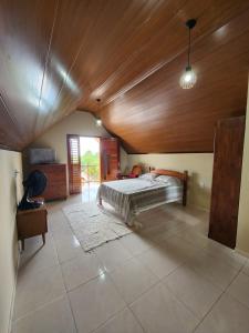 a bedroom with a bed and a wooden ceiling at Chalé Kalmaria in Guaramiranga +20 photos