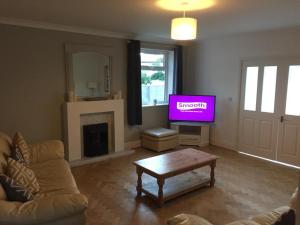 a living room with a couch and a tv at Cederee in Rhyl