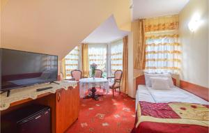 a hotel room with a bed and a television and a table at Amazing Aparthotel In Pogorzelica With Wifi in Pogorzelica