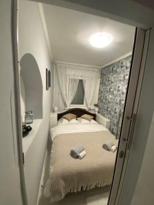 a small bedroom with a bed with a window at Apartman Kali in Banja Luka