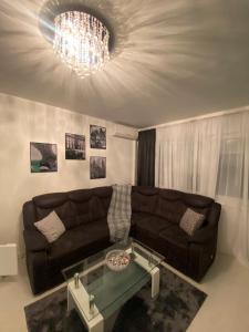 a living room with a couch and a chandelier at Apartman Kali in Banja Luka