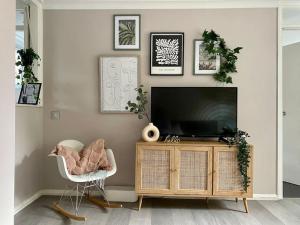 a living room with a television and a chair at Stylish Apartment in Leafy Ealing in Ealing