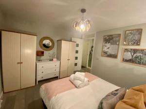 sypialnia z dużym łóżkiem i komodą w obiekcie Stylish Apartment in Leafy Ealing w mieście Ealing