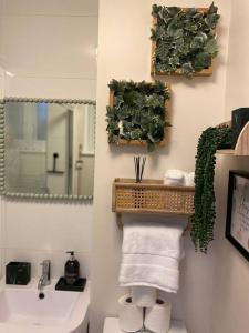 W łazience znajduje się umywalka, toaleta i lustro. w obiekcie Stylish Apartment in Leafy Ealing w mieście Ealing