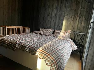a bed with a checkered blanket and pillows at Kikut Alpin Lodge - Ski In/Ski Out - Ny 2022 in Geilo