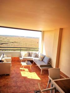 イスラ・カネラにあるLas Marismas de Isla Canelaのソファと大きな窓のあるリビングルーム