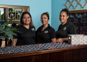 três mulheres em pé em frente a uma mesa em Roxy's Bed & Breakfast em Boca Chica