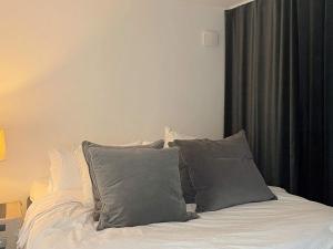 a bed with gray pillows on it in a bedroom at Holiday home Onsala IV in Onsala