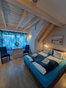 a bedroom with a large bed and two chairs at Apartamenty Polanki 2 in Łeba