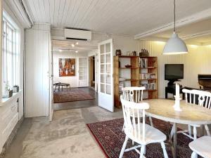 Holiday home LIDKÖPING VIII في ليدكوبينغ: غرفة طعام وغرفة معيشة مع طاولة وكراسي