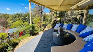 een patio met een bank en een tafel op een veranda bij Como Guest Suite in Gold Coast