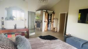 een slaapkamer met een bed, een bank en een spiegel bij Como Guest Suite in Gold Coast