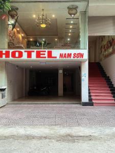 uma entrada principal do hotel com uma placa principal do hotel em Khách Sạn Nam Sơn em Ðoan Xá