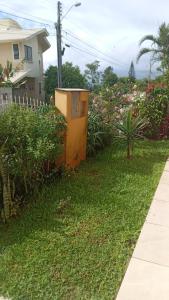 una caja amarilla en el patio de una casa en Casa no Campeche em ambiente familiar, en Florianópolis