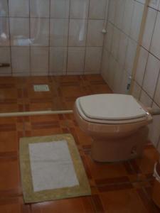 y baño con aseo y alfombra. en Casa no Campeche em ambiente familiar, en Florianópolis