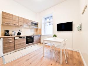 a kitchen with a table and a tv on a wall at Tolstov Apartments - 1 or 4 Room Apartments - 15 Min to Messe DUS - 10 Min Old Town DUS in Düsseldorf